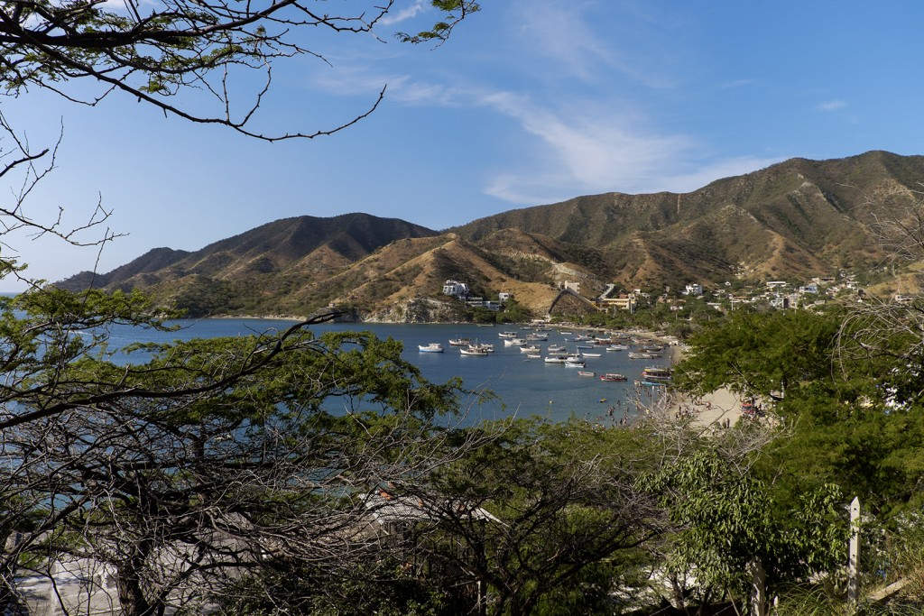 Tourists play in the cool waters among anchored fishing boats in the Caribbean town of Taganga, Colombia.